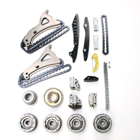 Timing chain kit components assortment with chain guides, gears, and mounting hardware
