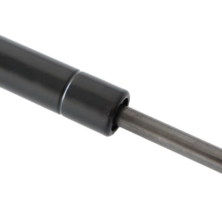 Trunk lift support gas strut with black end bushing and metal piston rod, close-up.