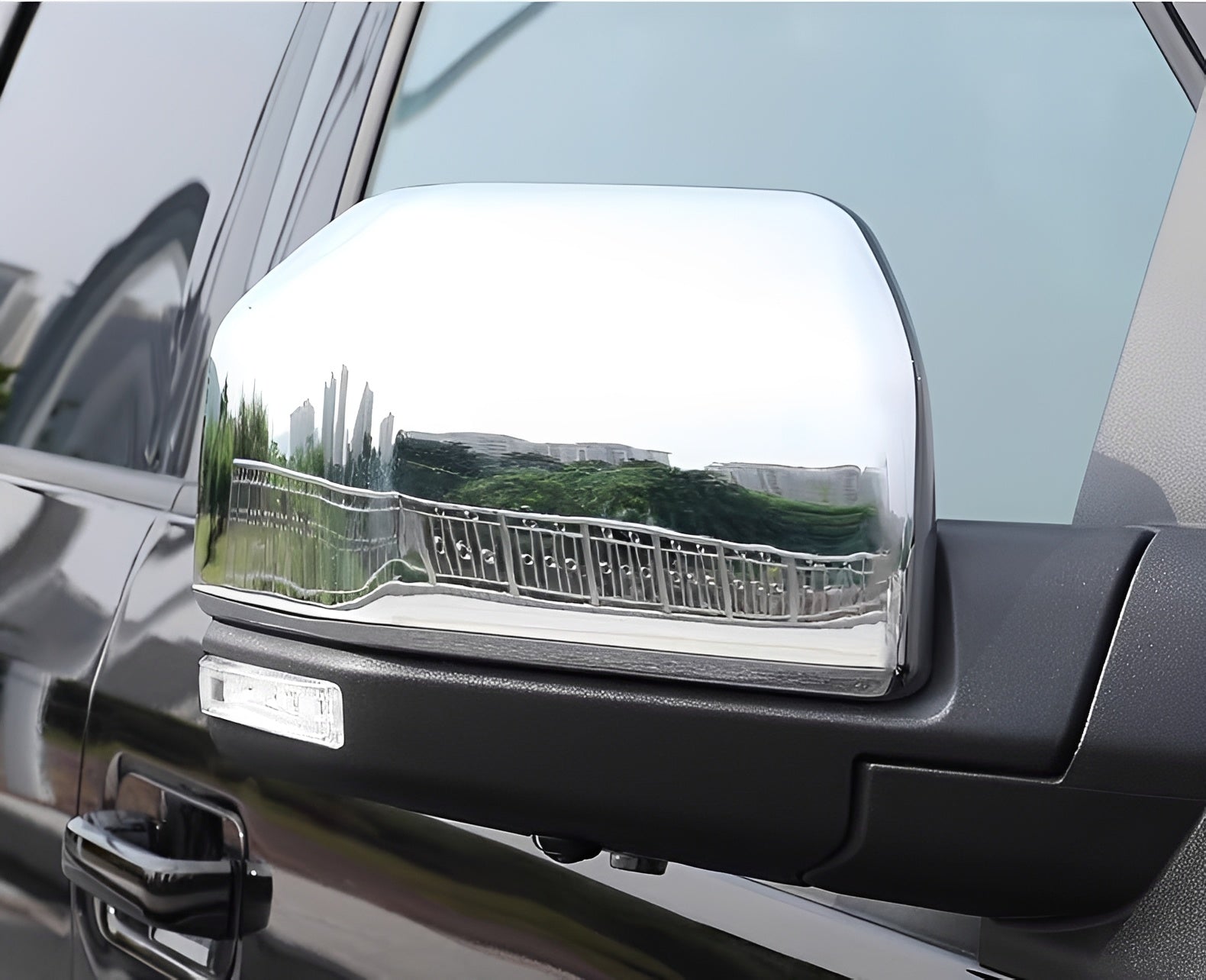 Polished chrome side mirror cover with reflective turn-signal style trim