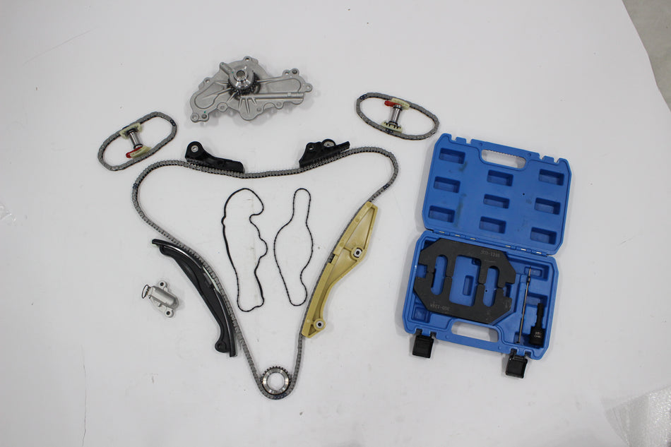 Timing chain kit parts laid out: water pump, chains, tensioners, guides, and sprockets